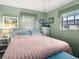 Cozy bedroom with pastel green walls, light-colored furniture, and plenty of natural light at 7816 38Th N Ter # 7816, St Petersburg, FL 33709