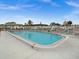 Community pool surrounded by a white fence with lounge chairs and tables at 7816 38Th N Ter # 7816, St Petersburg, FL 33709