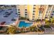 Aerial view of condo building with pool, palm trees, and parking lot at 830 S Gulfview Blvd # 501, Clearwater Beach, FL 33767