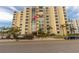 Low angle view of condo building's exterior with many windows and palm trees outside at 830 S Gulfview Blvd # 501, Clearwater Beach, FL 33767