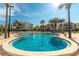 Large community pool surrounded by lounge chairs and palm trees for relaxation at 830 S Gulfview Blvd # 501, Clearwater Beach, FL 33767