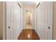 Hallway with hardwood flooring and multiple storage closets, leading to a bathroom at 830 S Gulfview Blvd # 501, Clearwater Beach, FL 33767