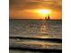 Calm ocean view at sunset, featuring a sailboat and a tranquil, scenic horizon at 830 S Gulfview Blvd # 501, Clearwater Beach, FL 33767
