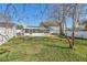 Well-maintained backyard with fenced-in pool, grassy area, and mature trees for shade at 908 Evelyn Ave, Clearwater, FL 33764