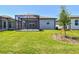 Backyard view showcasing the screened in patio and lush lawn at 9412 Coastline Way, Parrish, FL 34219