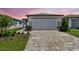 Charming single-story home with a large two-car garage, brick driveway, and well-manicured landscaping at 9412 Coastline Way, Parrish, FL 34219