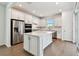 Bright, modern kitchen with stainless steel appliances, an island, white cabinets, and ample counter space at 9412 Coastline Way, Parrish, FL 34219
