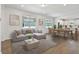 Open-concept living area featuring modern decor, a comfortable sectional, and an adjacent dining area with seating for six at 9412 Coastline Way, Parrish, FL 34219