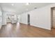 Spacious living room with hard wood floors that flows into an open kitchen with white cabinets at 9412 Coastline Way, Parrish, FL 34219