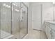 Modern bathroom showcasing a glass shower with a built-in bench and white cabinets at 9466 Shorebird Ct, Parrish, FL 34219