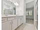 Elegant bathroom featuring double sinks, white cabinets, and a glass-enclosed shower at 9466 Shorebird Ct, Parrish, FL 34219