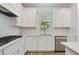 Close-up of bright kitchen with stainless appliances, white cabinets and wood floors at 9466 Shorebird Ct, Parrish, FL 34219