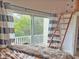 Bedroom featuring a loft, ladder, and a large window with views of the surrounding trees at 1050 Starkey Rd # 106, Largo, FL 33771