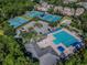 Overhead view of community pool and tennis courts surrounded by trees and residential homes at 10620 Tavistock Dr, Tampa, FL 33626