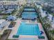 Aerial view of community pool and tennis courts with neighborhood homes and canal in the background at 10620 Tavistock Dr, Tampa, FL 33626