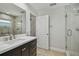 Updated bathroom featuring a glass-enclosed shower, dark cabinets, and dual sinks with white countertop at 10620 Tavistock Dr, Tampa, FL 33626