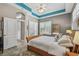 Bedroom with tile flooring, plantation shutters, and a teal accent on the ceiling at 10620 Tavistock Dr, Tampa, FL 33626