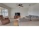 Bright living room with a ceiling fan, large sectional couch, and window at 12029 Gillingham Harbor Ln, Gibsonton, FL 33534