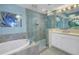 Bright bathroom features a glass shower, soaking tub, and white cabinets at 1325 Snell Isle Ne Blvd # 611, St Petersburg, FL 33704