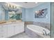Bright bathroom offers soaking tub, white cabinets and countertop, and large mirror at 1325 Snell Isle Ne Blvd # 611, St Petersburg, FL 33704