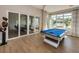 Bright game room with a blue felt pool table, wood floors, and sliding glass doors to a conference room at 1325 Snell Isle Ne Blvd # 611, St Petersburg, FL 33704