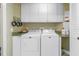 Laundry room with side by side washer and dryer and overhead cabinets at 1325 Snell Isle Ne Blvd # 611, St Petersburg, FL 33704