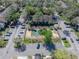 Aerial view featuring a tennis court surrounded by lush landscaping, parking, and a well-maintained community at 13385 Arbor Pointe Cir # 203, Tampa, FL 33617