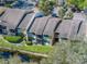 Aerial view featuring condo building with landscaping and a canal, and mature trees throughout the property at 13385 Arbor Pointe Cir # 203, Tampa, FL 33617