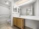 Bright bathroom with a large mirror, vanity with wooden cabinets, and a shower-tub combination at 13385 Arbor Pointe Cir # 203, Tampa, FL 33617