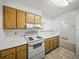 Open-concept kitchen featuring wooden cabinets and white appliances, with views to other rooms at 13385 Arbor Pointe Cir # 203, Tampa, FL 33617