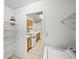 View of the kitchen from a laundry room, showcasing wooden cabinets and white appliances at 13385 Arbor Pointe Cir # 203, Tampa, FL 33617