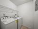 Practical laundry room equipped with a washer, dryer, and shelving for storage solutions at 13385 Arbor Pointe Cir # 203, Tampa, FL 33617