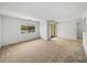 Bright living room featuring neutral carpet, sliding door, and a large window providing ample natural light at 13385 Arbor Pointe Cir # 203, Tampa, FL 33617