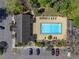 Aerial shot of a sparkling pool with lounge chairs, landscaping, and adjacent building at 13385 Arbor Pointe Cir # 203, Tampa, FL 33617