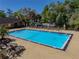 Community pool area featuring lounge chairs, a well-kept building, and beautiful landscaping at 13385 Arbor Pointe Cir # 203, Tampa, FL 33617