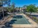 A pristine tennis court with green surface, surrounded by trees and condominium buildings, perfect for recreational enjoyment at 13385 Arbor Pointe Cir # 203, Tampa, FL 33617