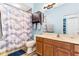Bathroom featuring a vanity with wood cabinets, toilet, and tub/shower with cloud-patterned curtain at 16313 Dinsdale Dr, Spring Hill, FL 34610