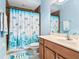 Bathroom with a blue shower curtain and a wood vanity at 16313 Dinsdale Dr, Spring Hill, FL 34610