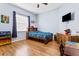 Cozy bedroom with colorful bedding, wood floors, and a window with natural light at 16313 Dinsdale Dr, Spring Hill, FL 34610