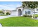 Charming one-story home featuring a well-manicured lawn, an arched entry, and a two car garage at 16313 Dinsdale Dr, Spring Hill, FL 34610
