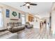 Spacious living room featuring wood floors, neutral walls, comfortable seating, and access to the kitchen at 16313 Dinsdale Dr, Spring Hill, FL 34610