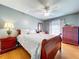 Bedroom with hardwood floors, ceiling fan, a large bed, and a wooden dresser at 17010 Aspen Meadows Dr, Lutz, FL 33548