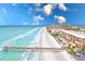 Stunning aerial view of a sandy beach with condos to the right and a pier to the left at 17940 Gulf Blvd # 2B, Redington Shores, FL 33708
