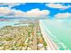 Beautiful aerial view of a coastal community with a sandy beach, clear water, and a line of houses along the shore at 17940 Gulf Blvd # 2B, Redington Shores, FL 33708