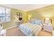 Cozy bedroom with a striped bed, desk, and bright natural light from the window at 17940 Gulf Blvd # 2B, Redington Shores, FL 33708