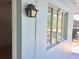 Exterior wall showing a classic lantern fixture, multi-pane window, and soft blue paint, adding to the building's charm at 1800 Pass A Grille Way # 5, St Pete Beach, FL 33706