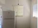 Kitchen area featuring a white refrigerator, white walls, and natural light from window with blinds at 1800 Pass A Grille Way # 5, St Pete Beach, FL 33706