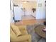 Living room area featuring a yellow chair with pillow, hardwood floors, and a refrigerator in the background at 1800 Pass A Grille Way # 5, St Pete Beach, FL 33706