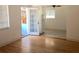 Living room area with hardwood floors, white trim, and a view into the backyard through a door at 1800 Pass A Grille Way # 5, St Pete Beach, FL 33706
