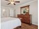 Bedroom with wood flooring, ceiling fan, dresser with mirror, and ample natural light at 18445 Bridle Club Dr, Tampa, FL 33647